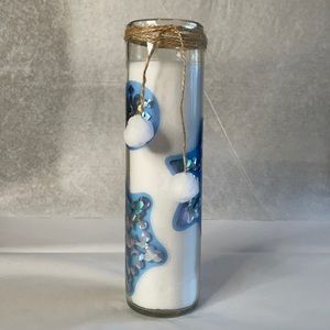 Candle white with snowflake details tied with brown twine and white puffballs‎
